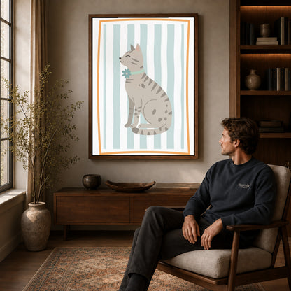 Tabby cat canvas art in a walnut frame above a console beside a seated man.