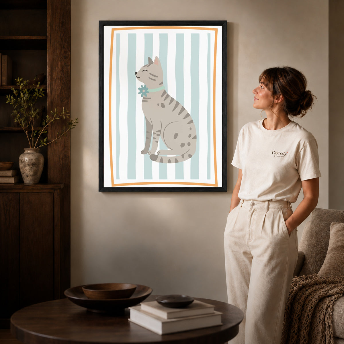 Tabby cat canvas art shown in the black frame option against a softly lit wall.