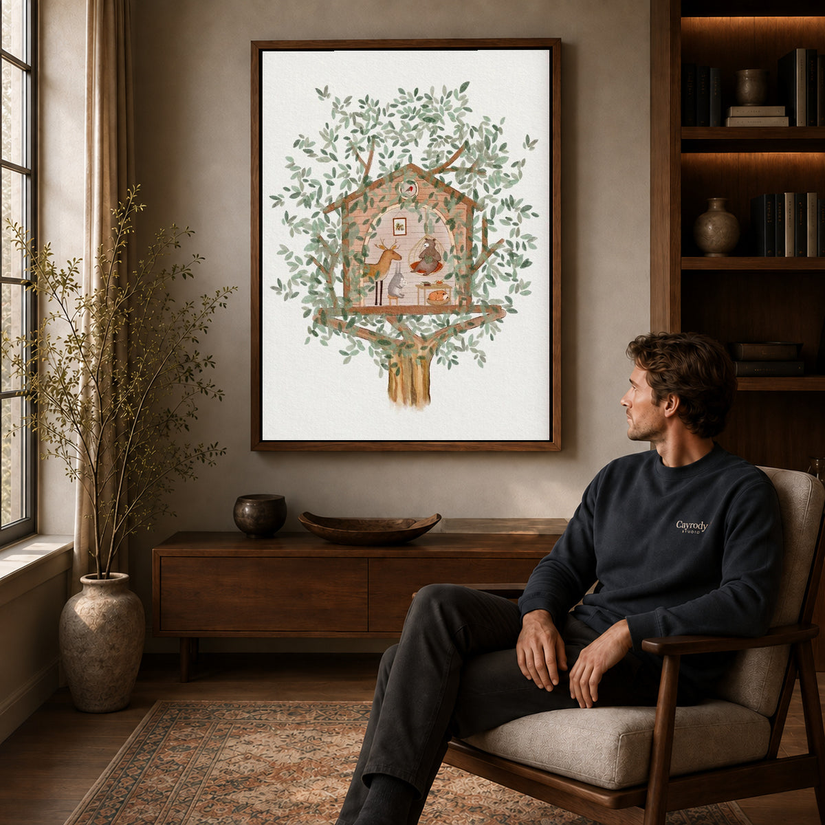 Woodland treehouse canvas art in a walnut frame above a console beside a seated man.