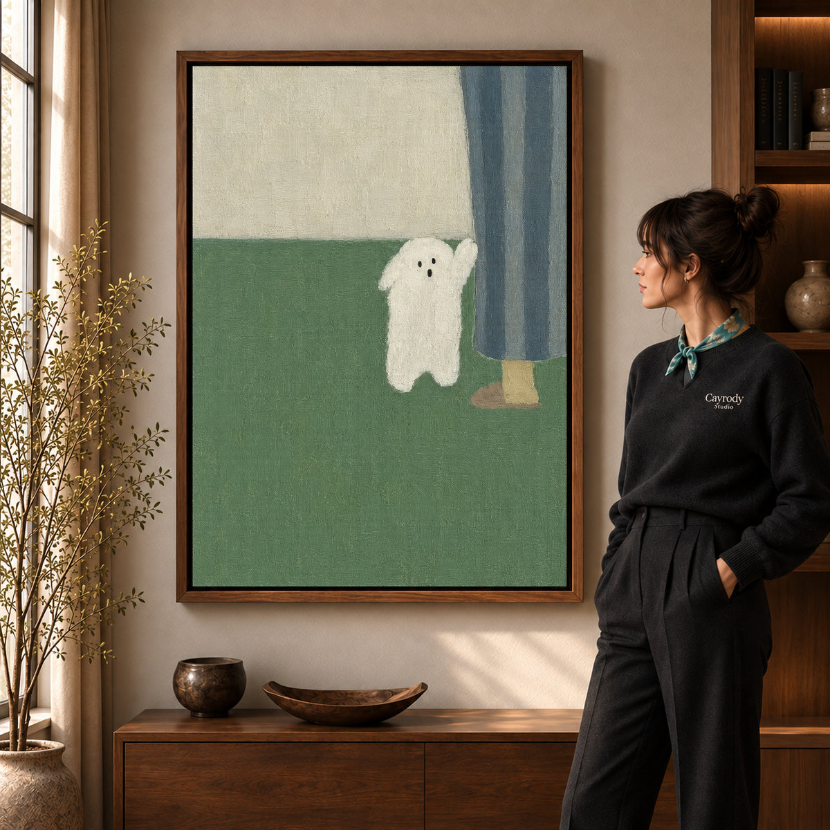 Little ghost canvas art in a walnut frame beside a standing woman and wooden console.