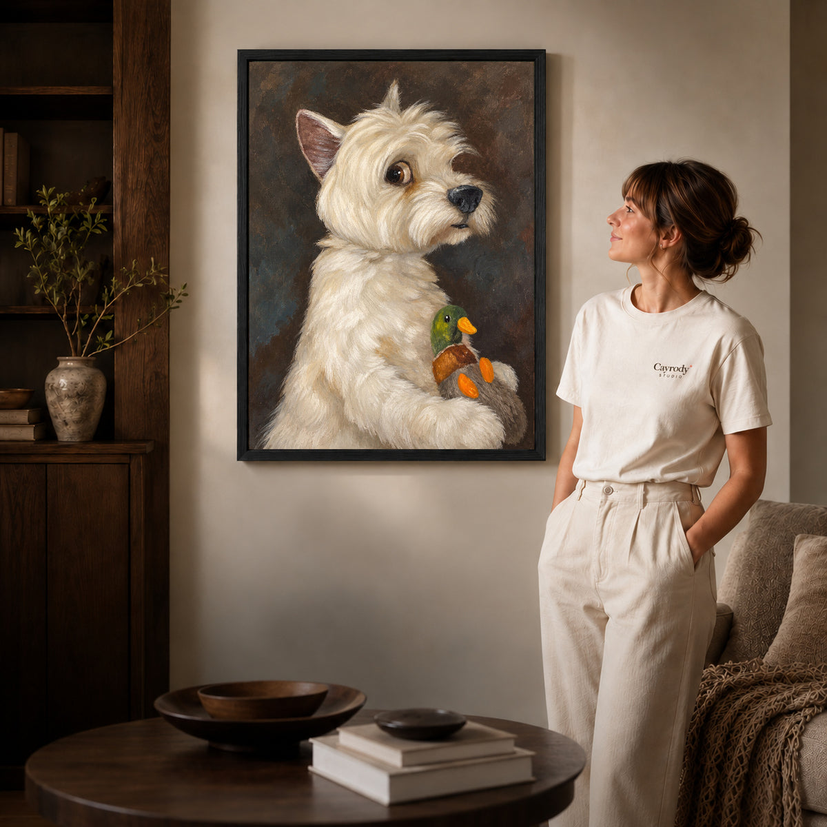 Terrier canvas art in a black frame beside a woman and round wooden table.