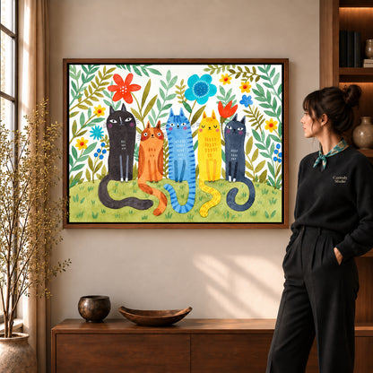 Garden cats canvas art in a walnut frame beside a standing woman and wooden console.