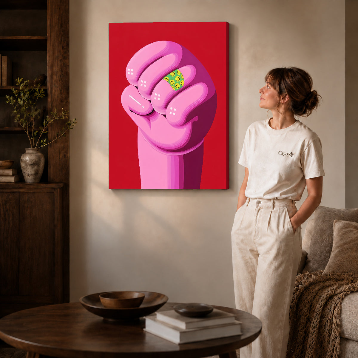 Pink Smiley Fist canvas art on gallery-wrapped canvas with natural edge shading beside a standing woman.