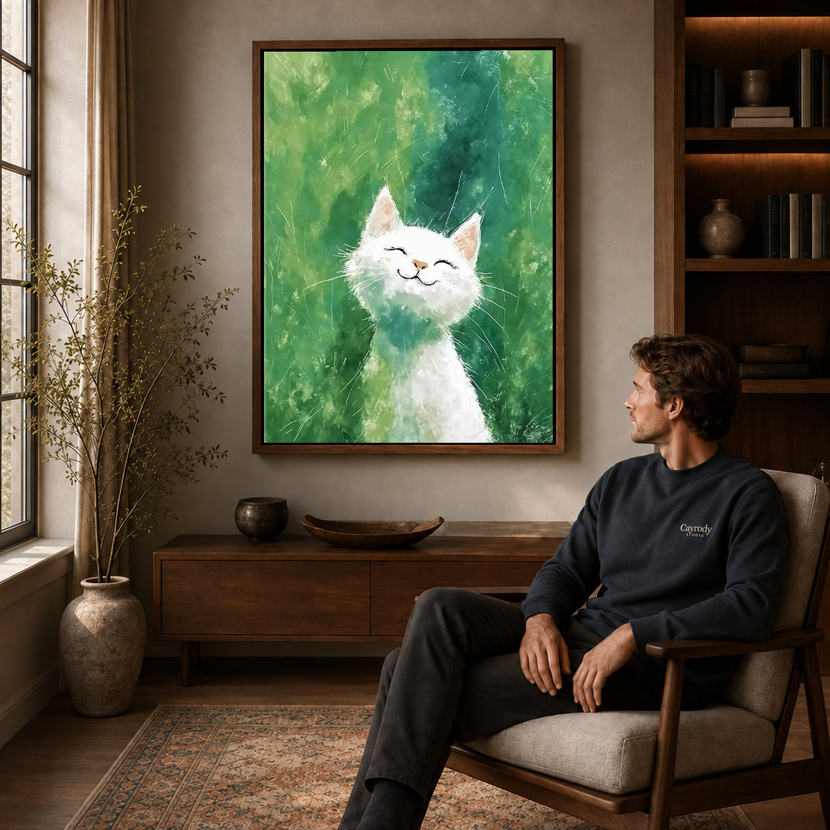White cat canvas art in a walnut frame above a console beside a seated man.