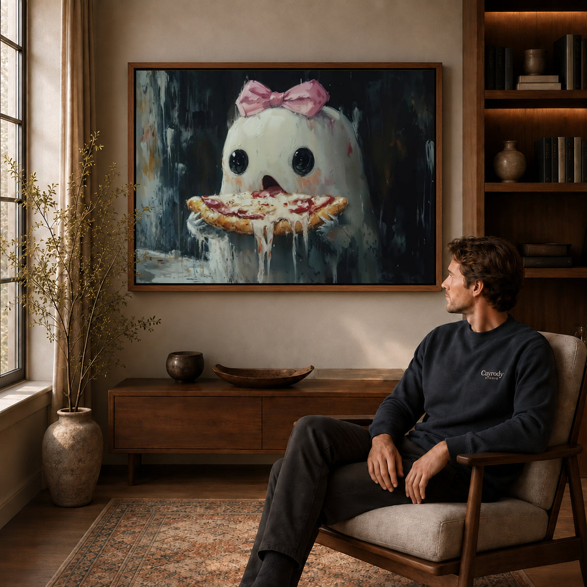 Pizza ghost canvas art in a walnut frame above a console beside a seated man.