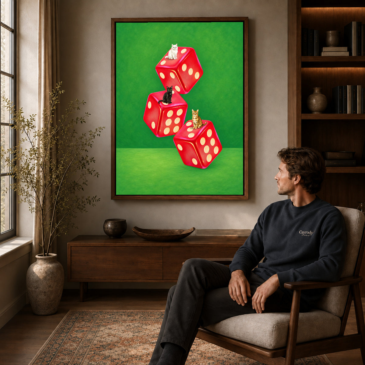 Cats and dice canvas art in a walnut frame above a console beside a seated man.