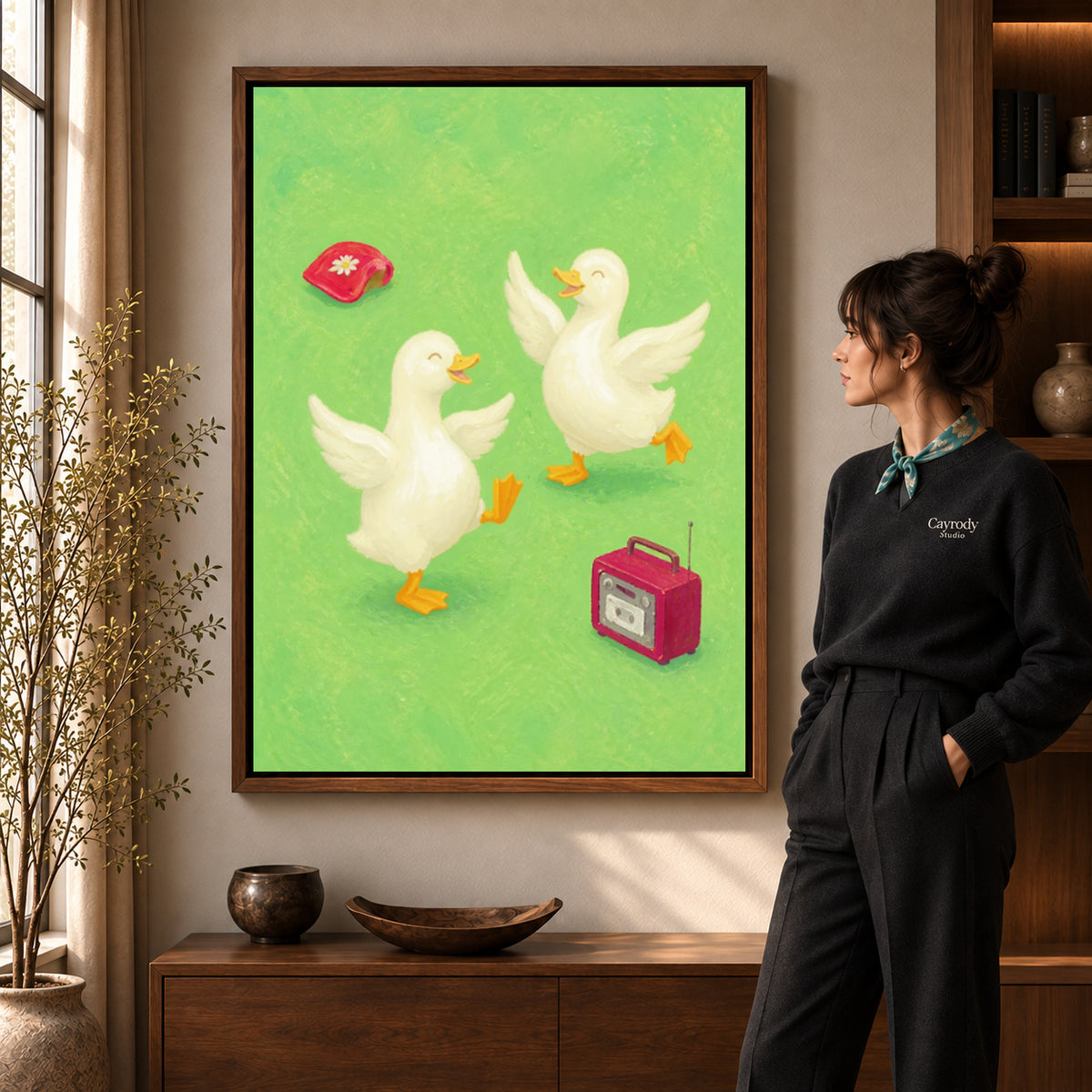 Dancing ducks canvas art in a walnut frame beside a standing woman and wooden console.