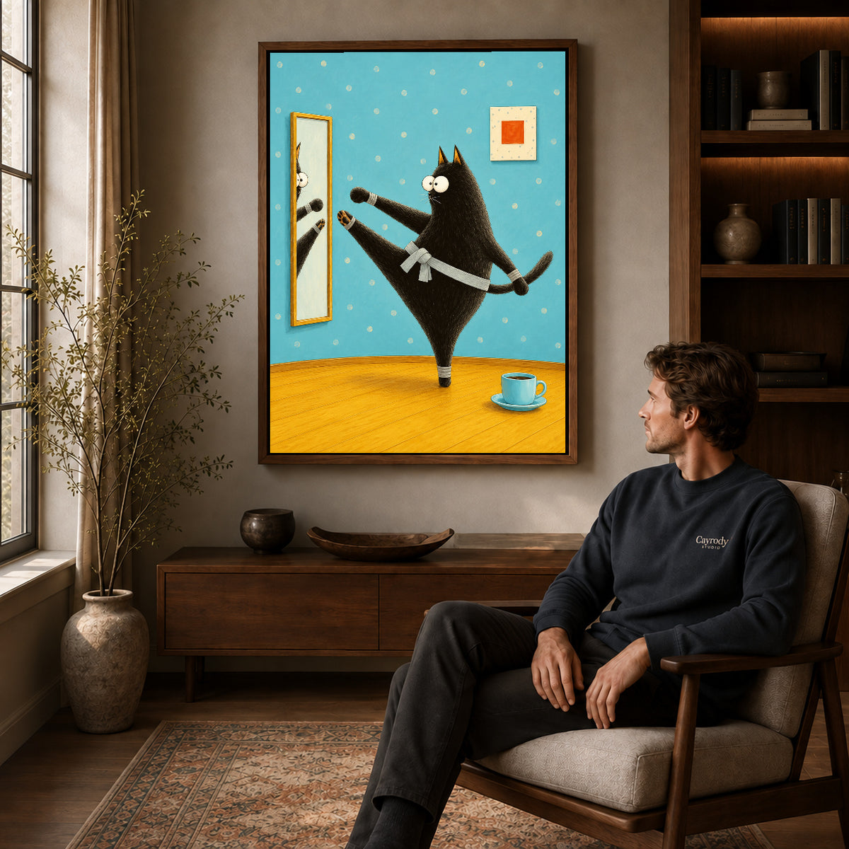 whimsical karate cat canvas art in a walnut frame above a console beside a seated man.