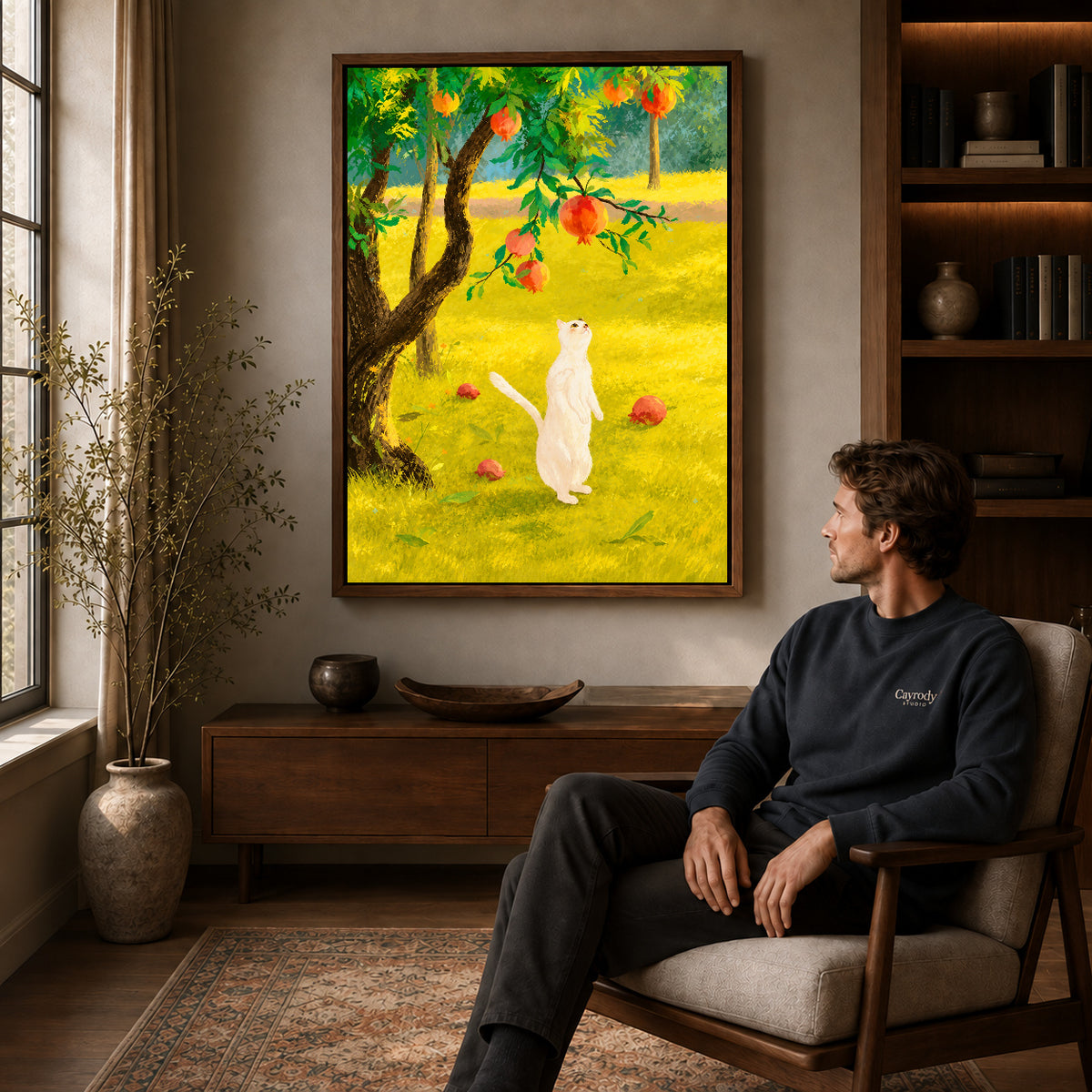 Orchard cat canvas art in a walnut frame above a console beside a seated man.