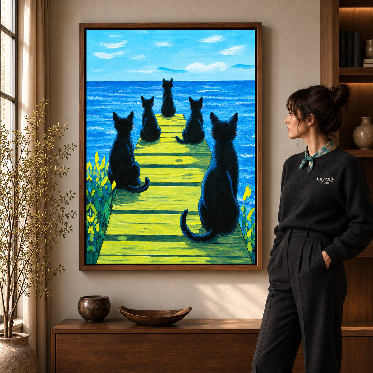 Cats ocean pier canvas art shown in the walnut frame option within a warm living room.