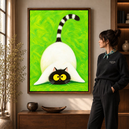 Playful cat canvas art in a walnut frame beside a standing woman and wooden console.