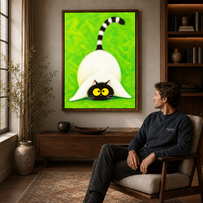 Playful cat canvas art in a walnut frame above a console beside a seated man.