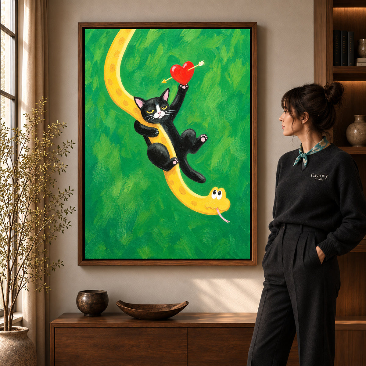 Cat and snake canvas art in a walnut frame beside a standing woman and wooden console.