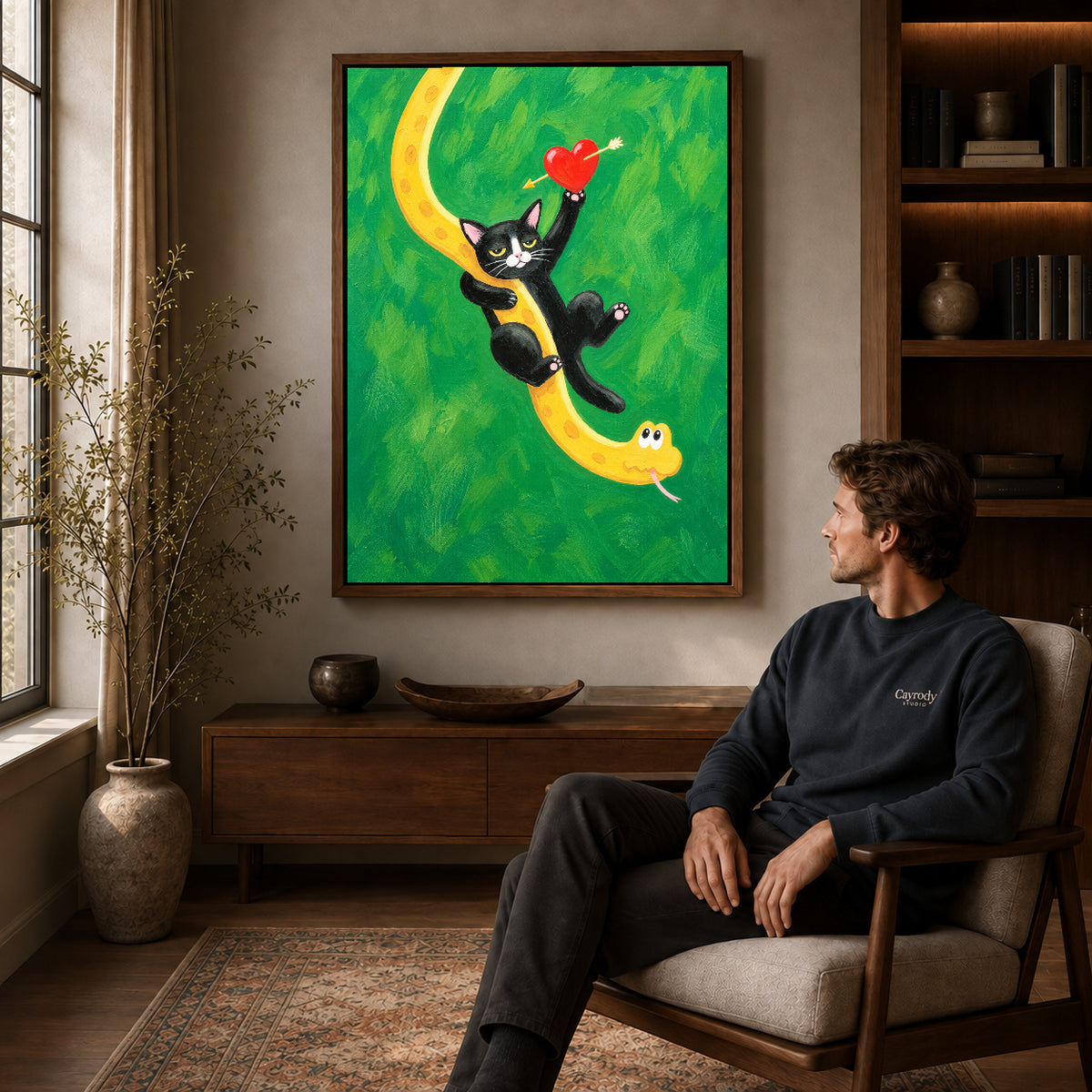 Cat and snake canvas art in a walnut frame above a console beside a seated man.