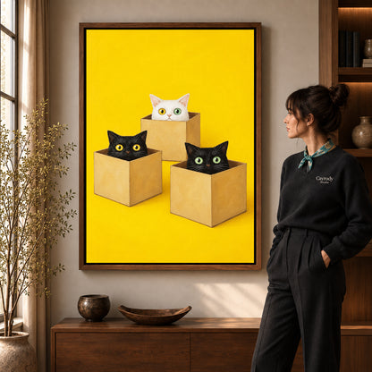 Cats in boxes canvas art in a walnut frame beside a standing woman and wooden console.