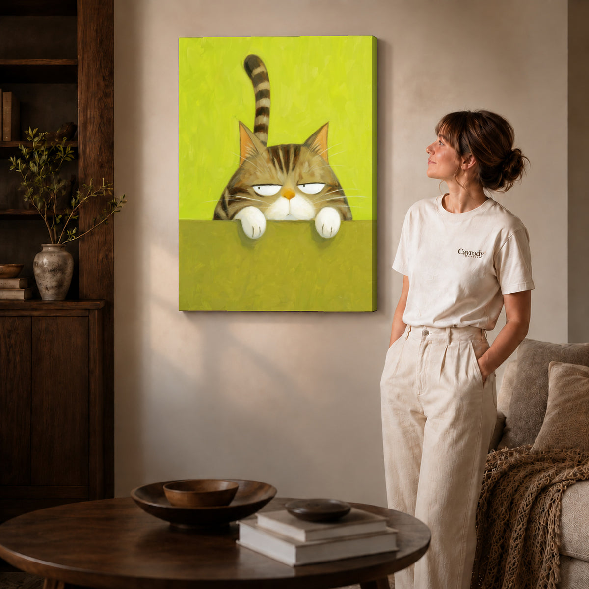 Grumpy tabby canvas art on gallery-wrapped canvas with natural edge shading beside a standing woman.