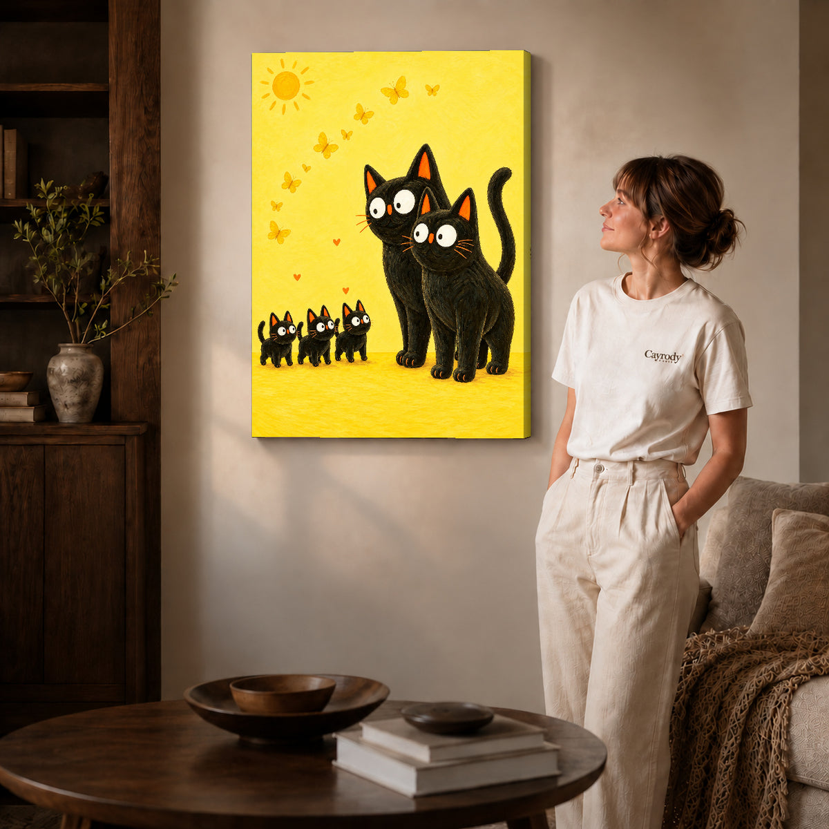 Black cat family canvas art on gallery-wrapped canvas with natural edge shading beside a standing woman.