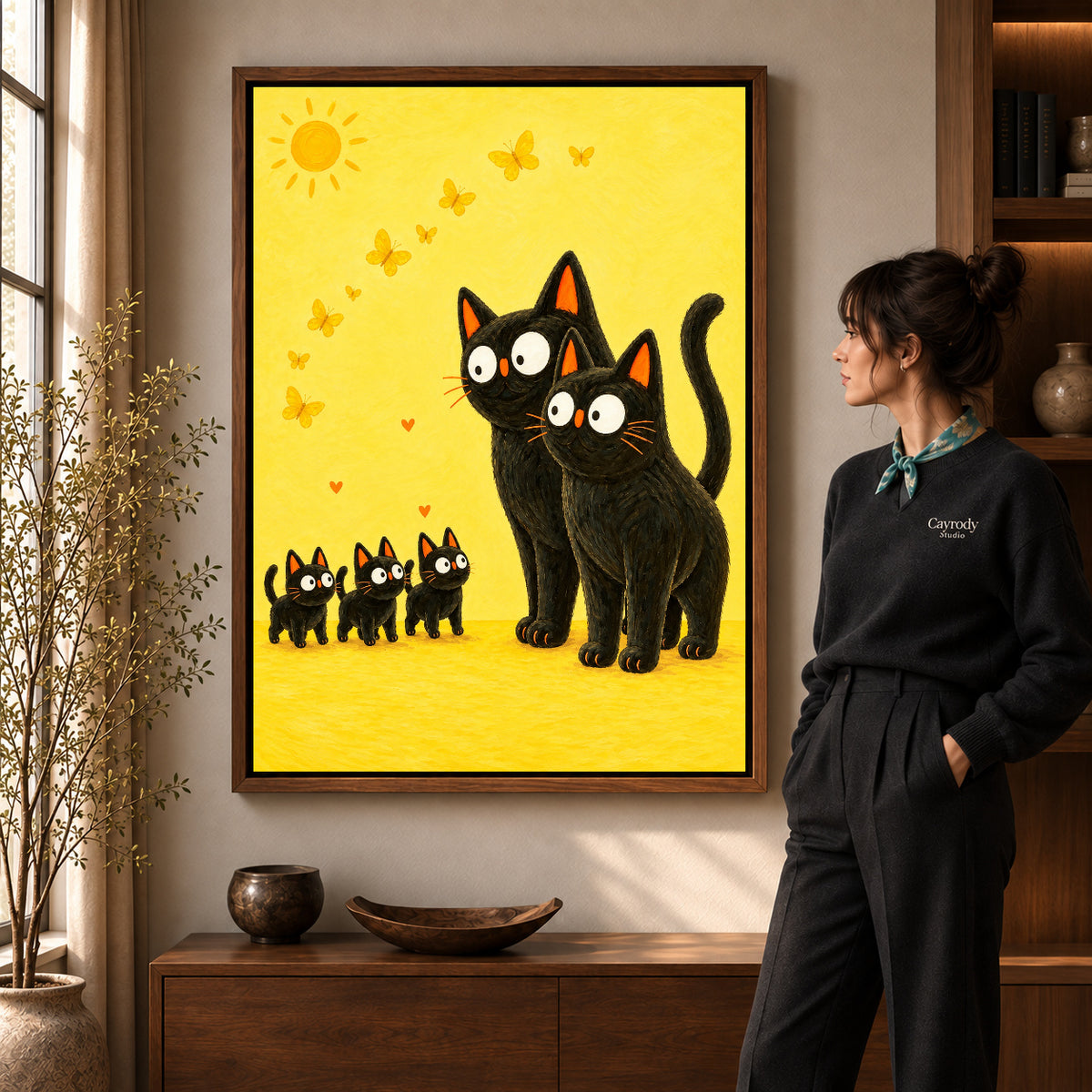 Black cat family canvas art shown in the walnut frame option within a warm living room.