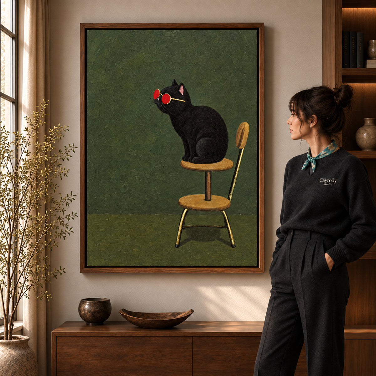 Sunglasses cat canvas art in a walnut frame beside a standing woman and wooden console.