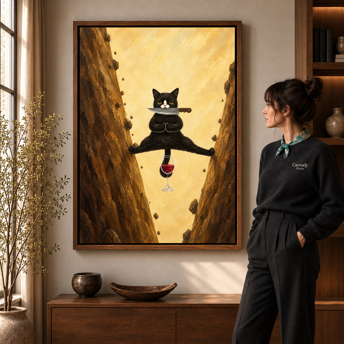 Acrobatic cat canvas art in a walnut frame beside a standing woman and wooden console.