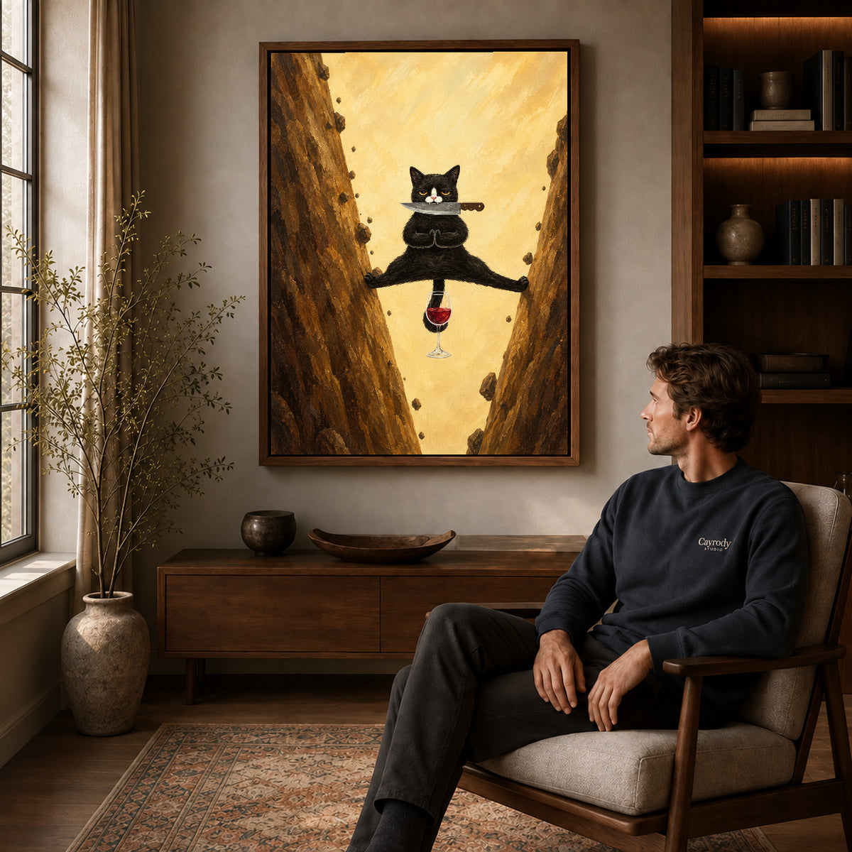 Acrobatic cat canvas art in a walnut frame above a console beside a seated man.