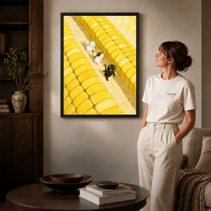 Farm cats canvas art in a black frame beside a woman and round wooden table.