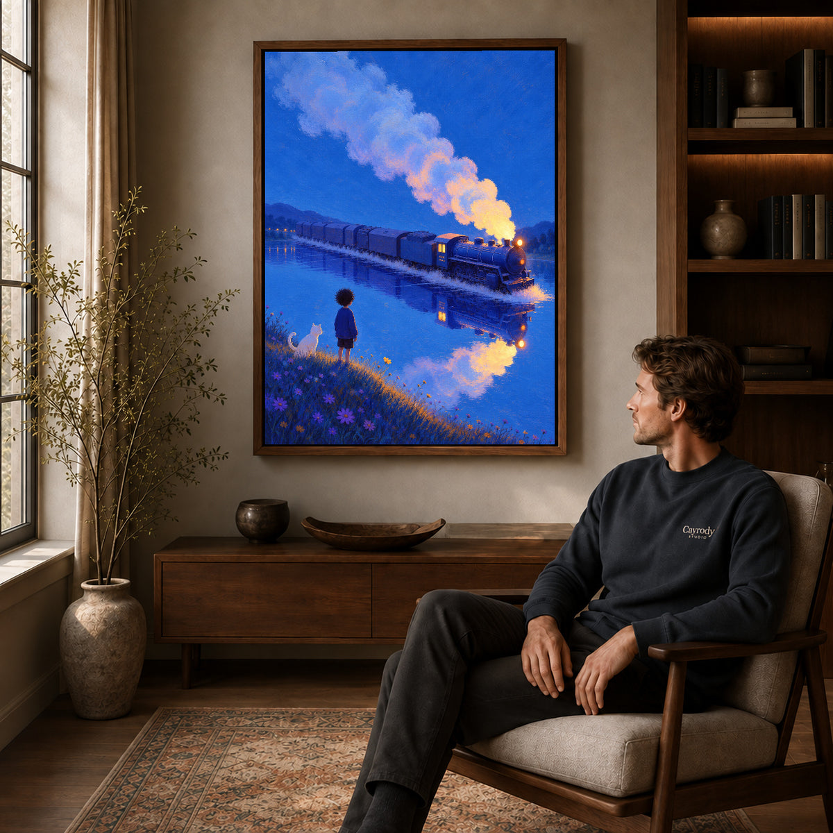 Train lake canvas art in a walnut frame above a console beside a seated man.