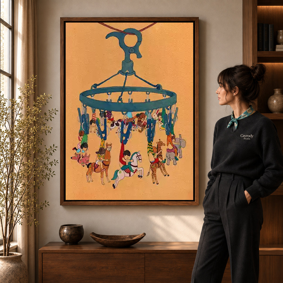 Hanging carousel canvas art in a walnut frame beside a standing woman and wooden console.