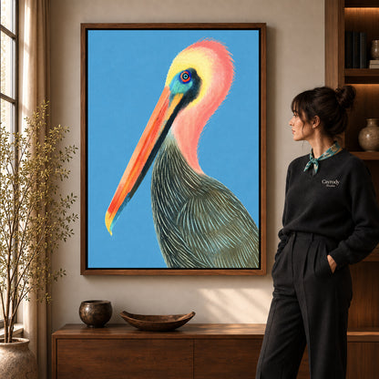Colorful pelican canvas art in a walnut frame beside a standing woman and wooden console.