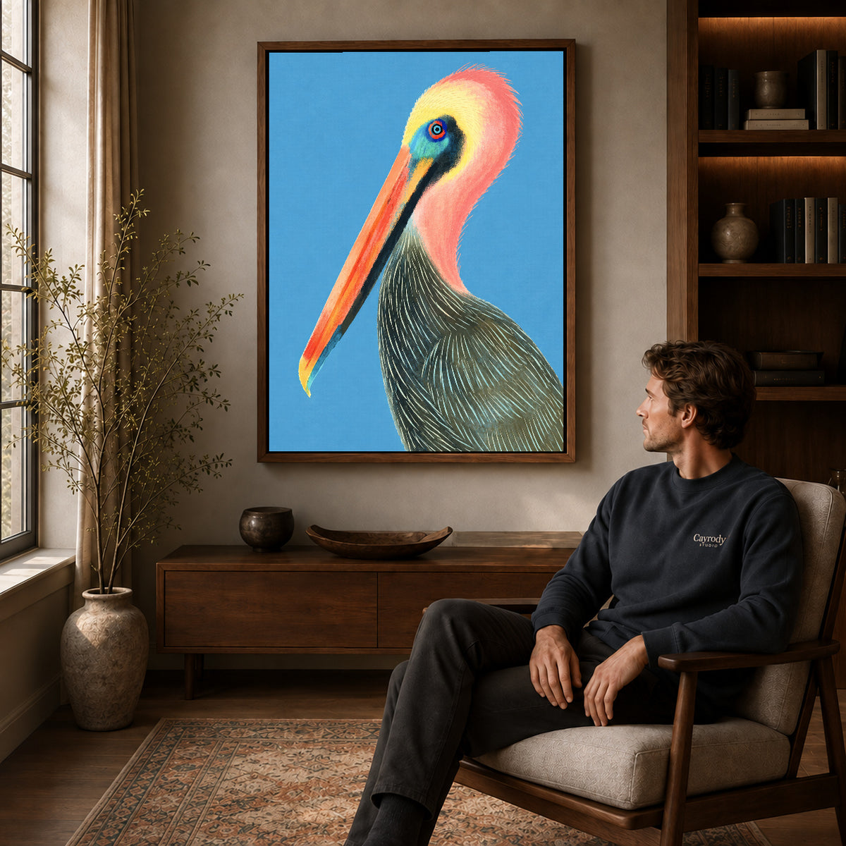 Colorful pelican canvas art in a walnut frame above a console beside a seated man.