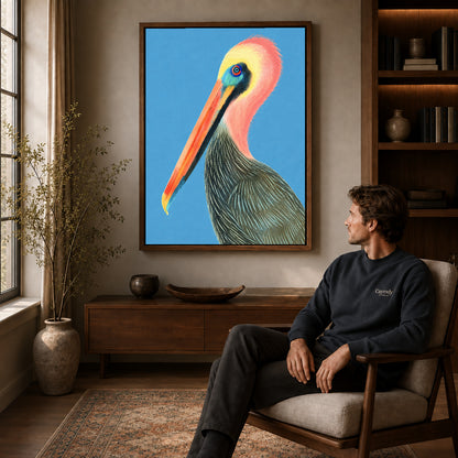 Colorful pelican canvas art in a walnut frame above a console beside a seated man.