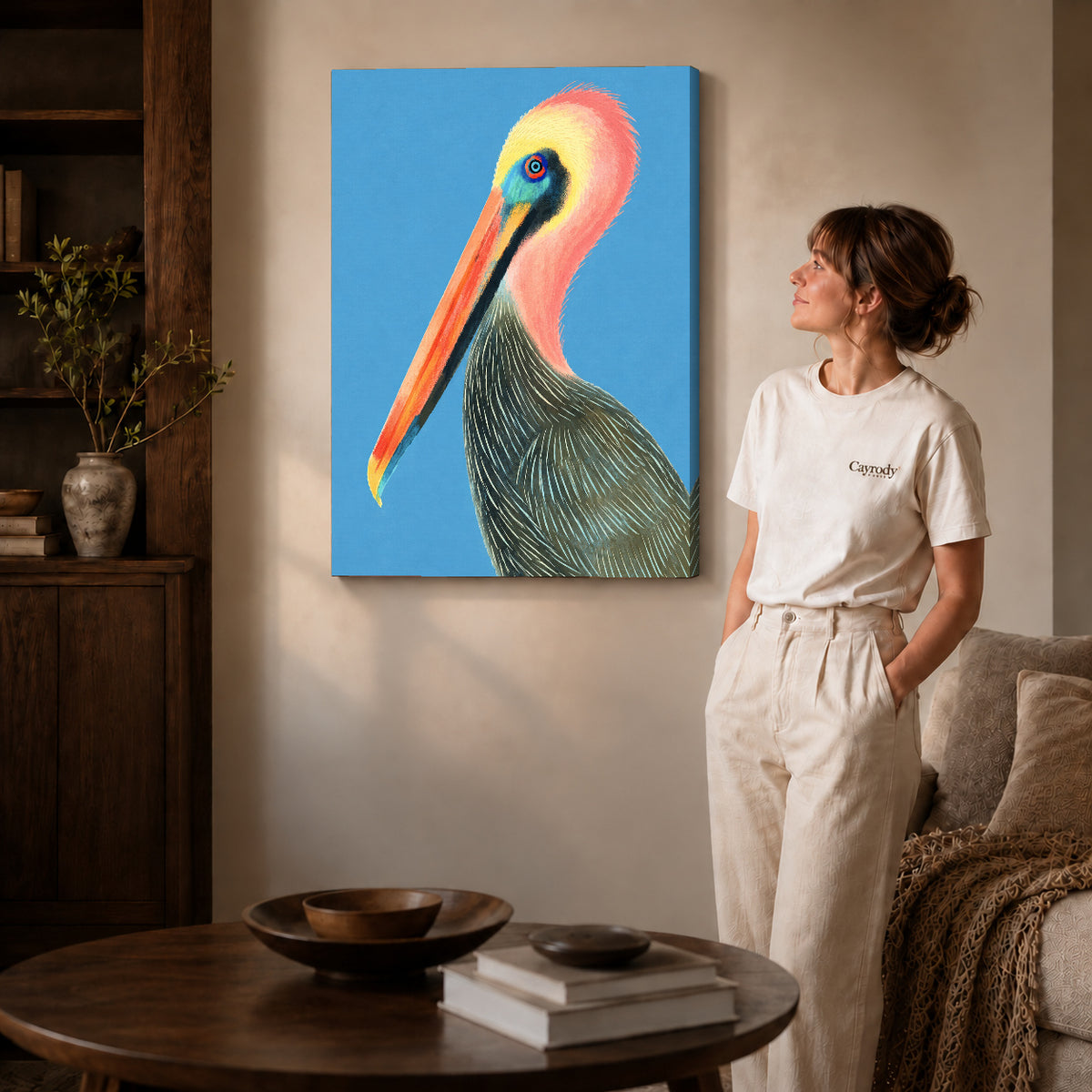 Colorful pelican canvas art on gallery-wrapped canvas with natural edge shading beside a standing woman.