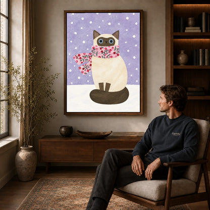Winter cat canvas art in a walnut frame above a console beside a seated man.