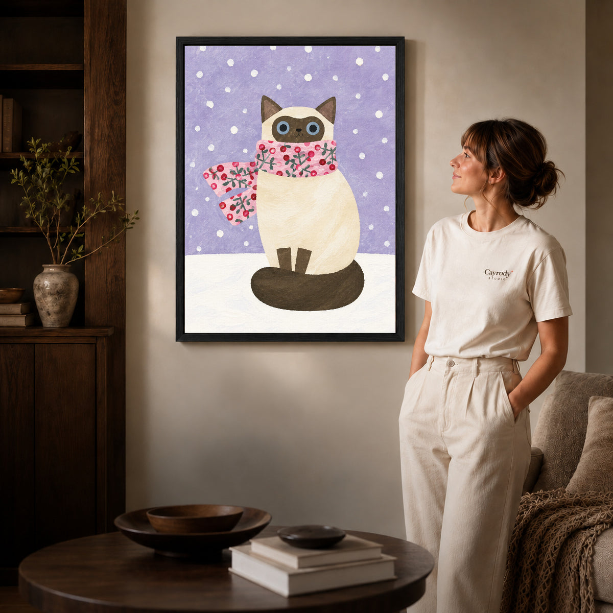 Winter cat canvas art shown in the black frame option against a softly lit wall.