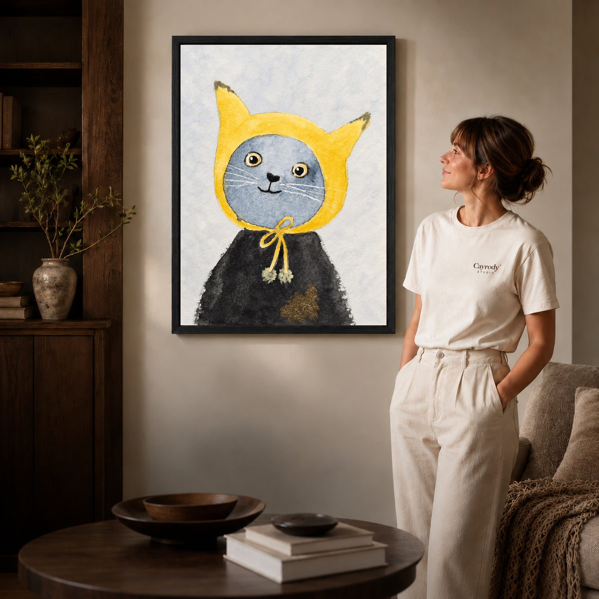 yellow hood cat canvas art shown in the black frame option against a softly lit wall.