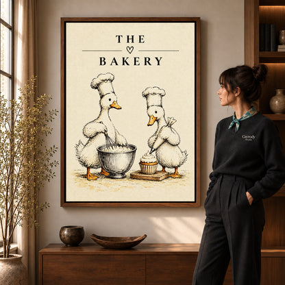 vintage bakery ducks canvas art in a walnut frame beside a standing woman and wooden console.