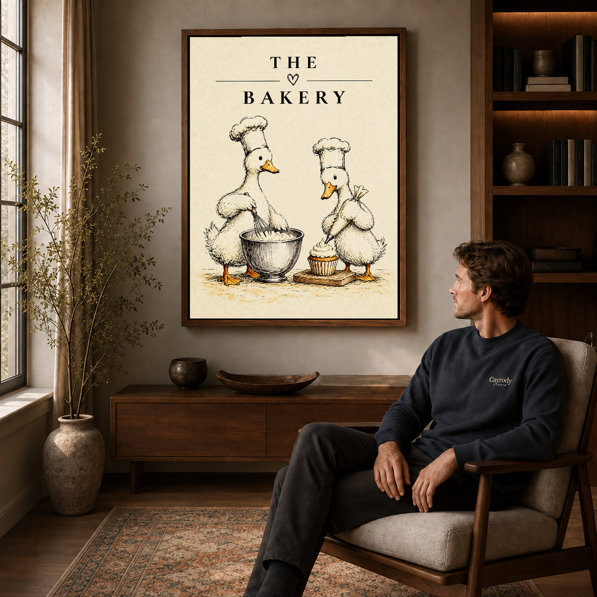 vintage bakery ducks canvas art in a walnut frame above a console beside a seated man.