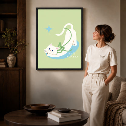 stretching white kitten canvas art in a black frame beside a woman and round wooden table.