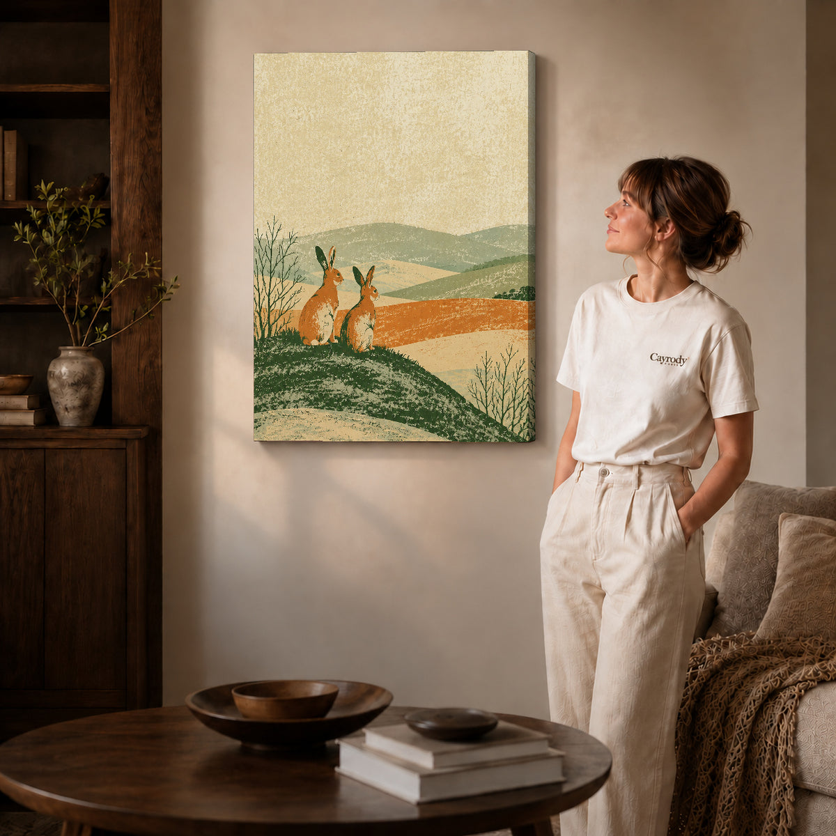 rustic rabbit landscape canvas art on gallery-wrapped canvas with natural edge shading beside a standing woman.