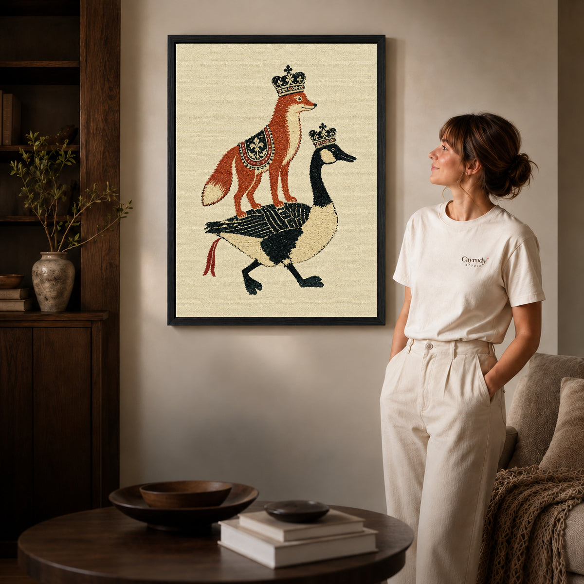 royal fox goose canvas art in a black frame beside a woman and round wooden table.