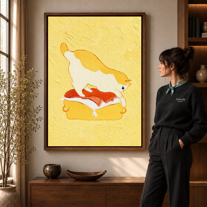 playful kneading cat canvas art in a walnut frame beside a standing woman and wooden console.