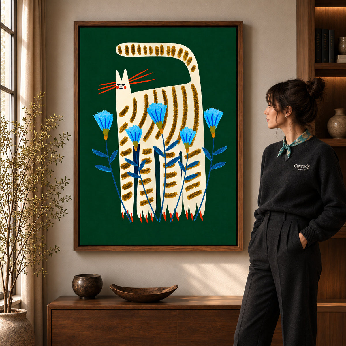 striped floral cat canvas art in a walnut frame beside a standing woman and wooden console.