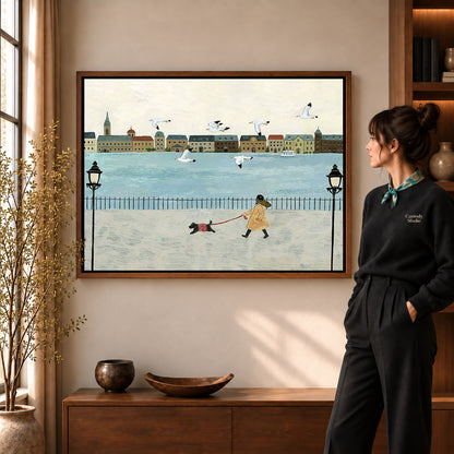 folk waterfront walk canvas art in a walnut frame beside a standing woman and wooden console.