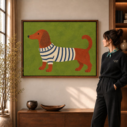 striped sweater dachshund canvas art in a walnut frame beside a standing woman and wooden console.
