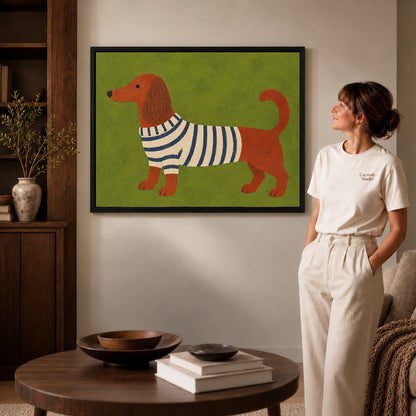 striped sweater dachshund canvas art in a black frame beside a woman and round wooden table.