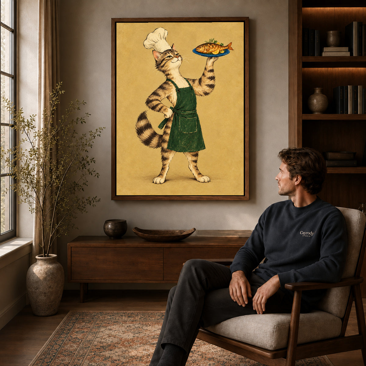 vintage fish chef cat canvas art in a walnut frame above a console beside a seated man.