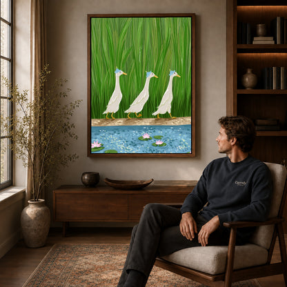 folk pond geese canvas art in a walnut frame above a console beside a seated man.
