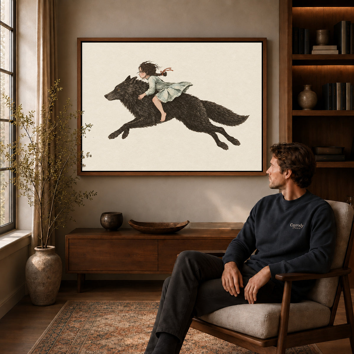 fairytale wolf rider canvas art in a walnut frame above a console beside a seated man.