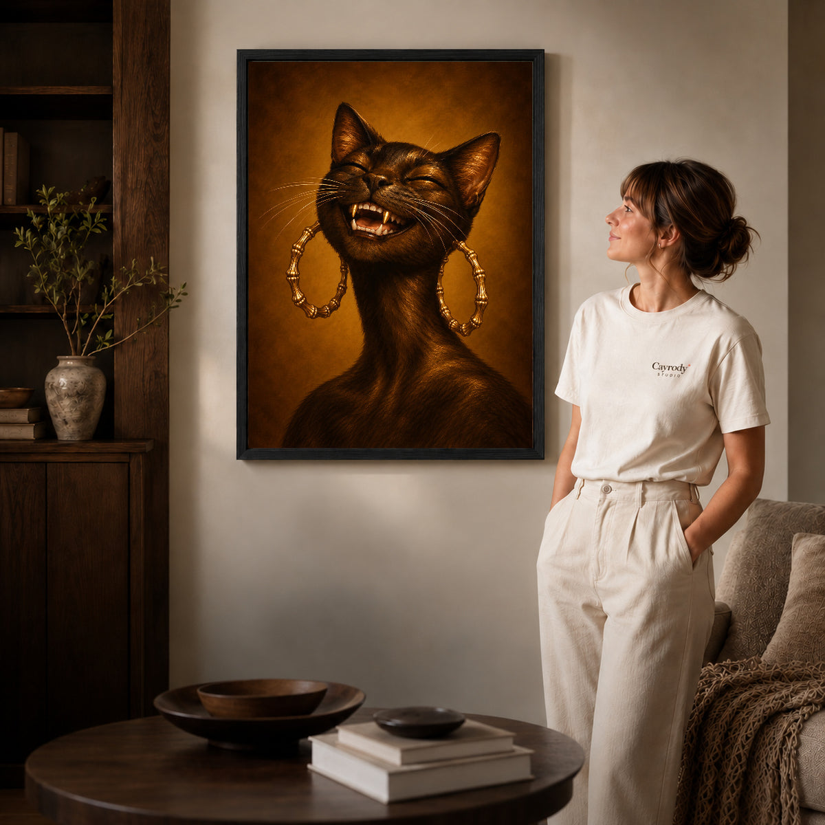 expressive golden cat canvas art in a black frame beside a woman and round wooden table.
