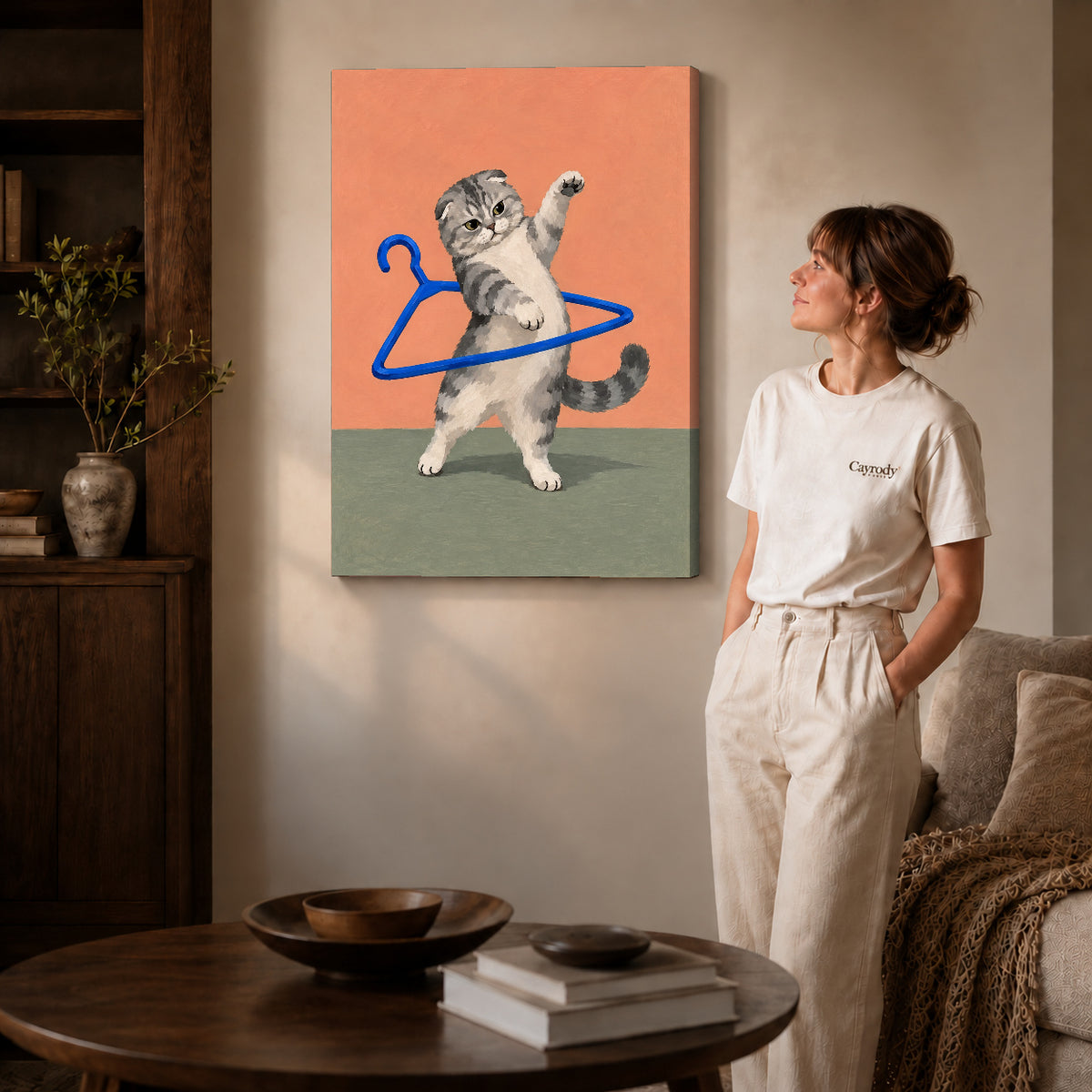 playful hanger kitten canvas art on gallery-wrapped canvas with natural edge shading beside a standing woman.